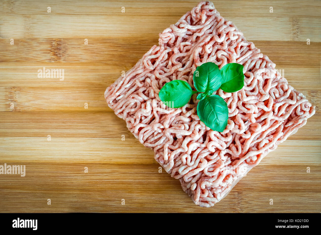 Carni macinate su uno sfondo di legno. Foto Stock