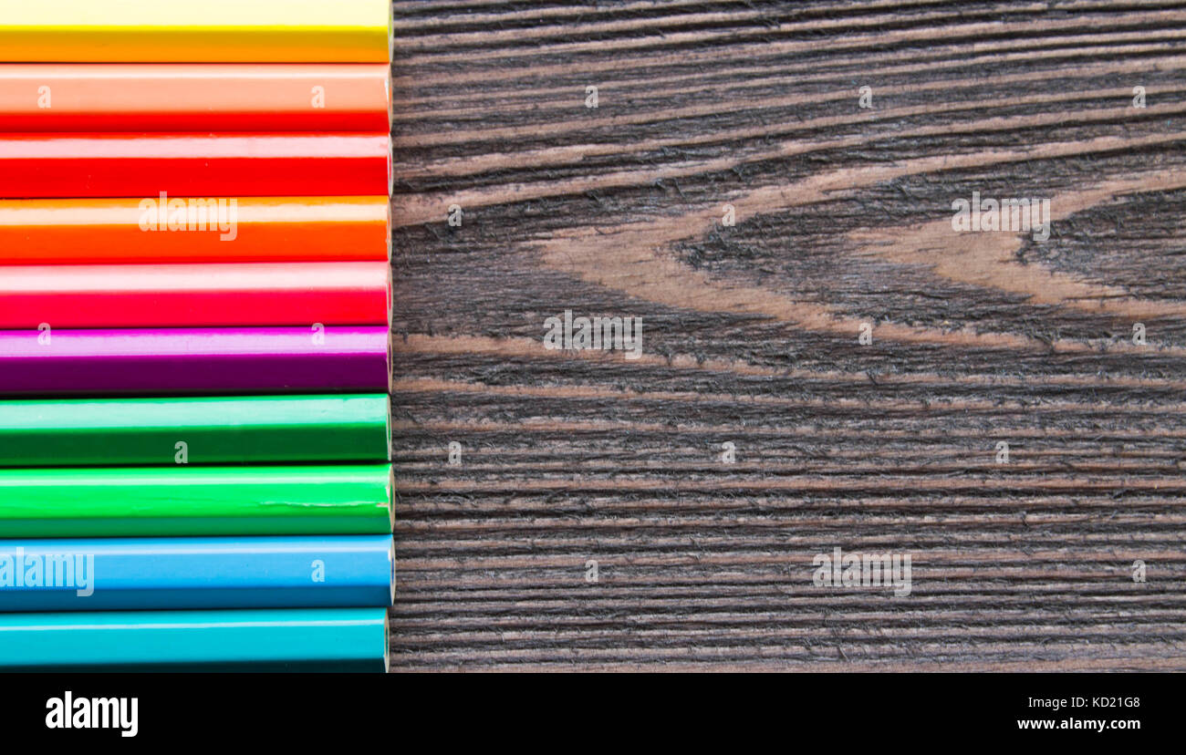 Matite colorate su uno sfondo di legno. Foto Stock
