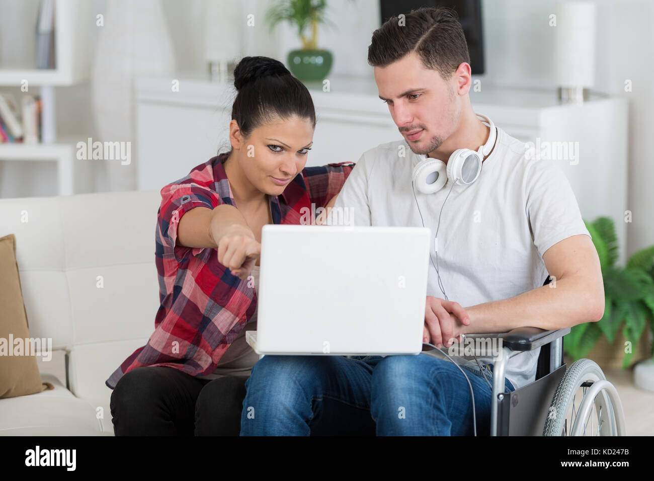 Disabilitato l'uomo utilizzando laptop seduto accanto alla sua ragazza Foto Stock