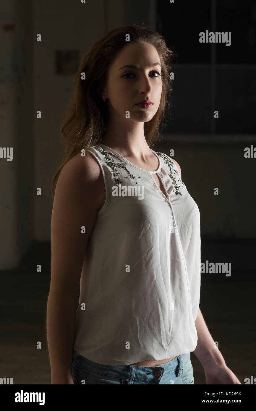 Bella giovane donna in piedi nel buio Foto Stock