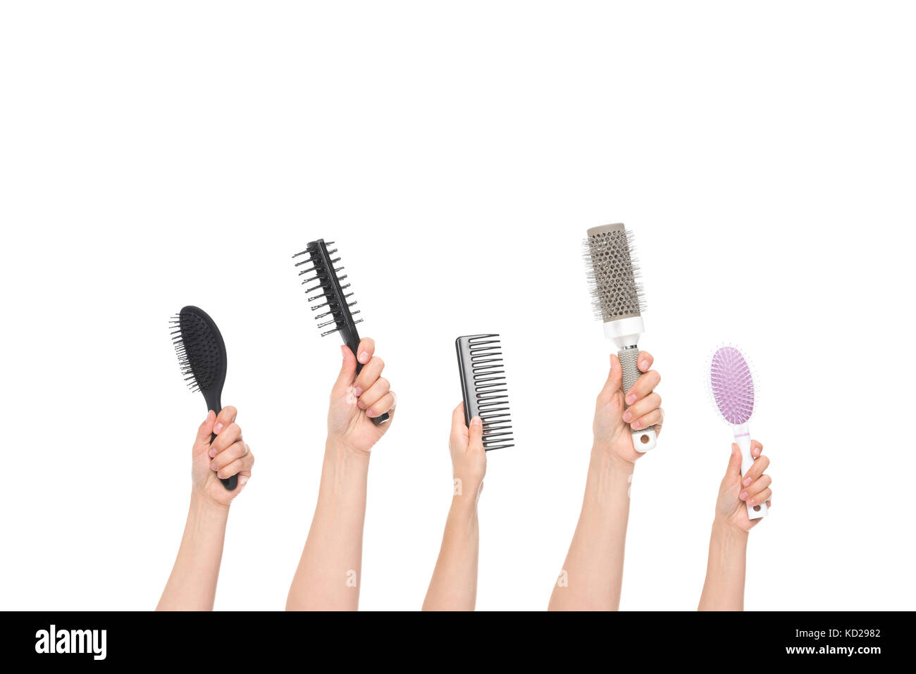 Mani tenendo le spazzole per capelli Foto Stock