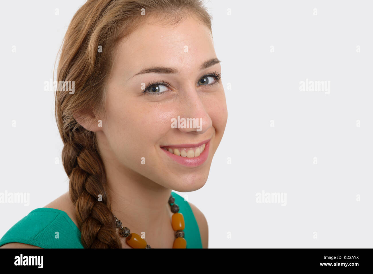 Una giovane donna sorridente nel verde smart casual abbigliamento, su bianco Foto Stock