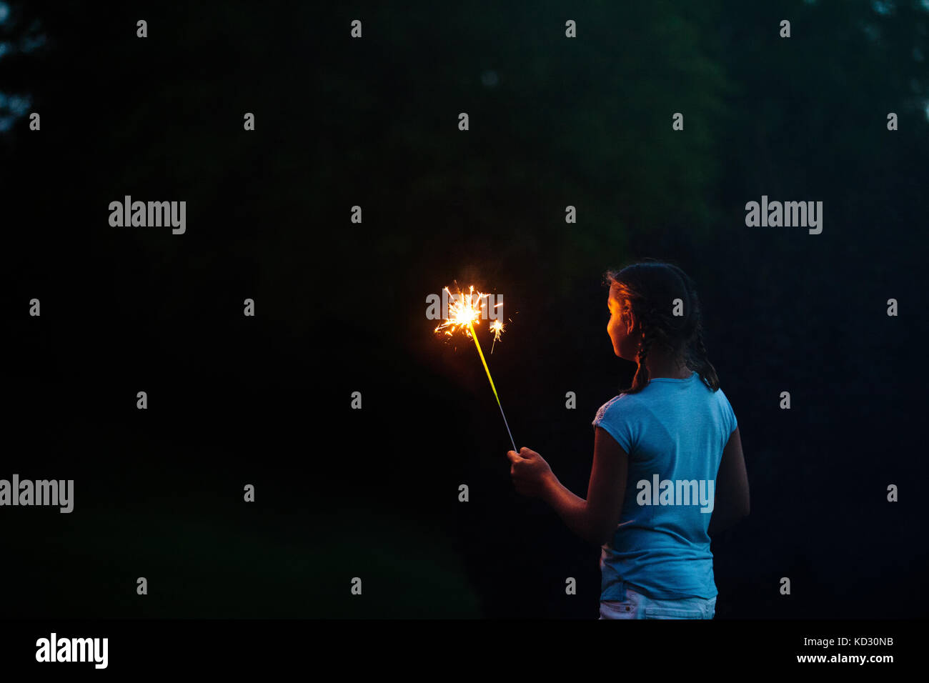 Ragazza ammirate sparkler in giardino durante la notte il giorno dell'indipendenza, STATI UNITI D'AMERICA Foto Stock
