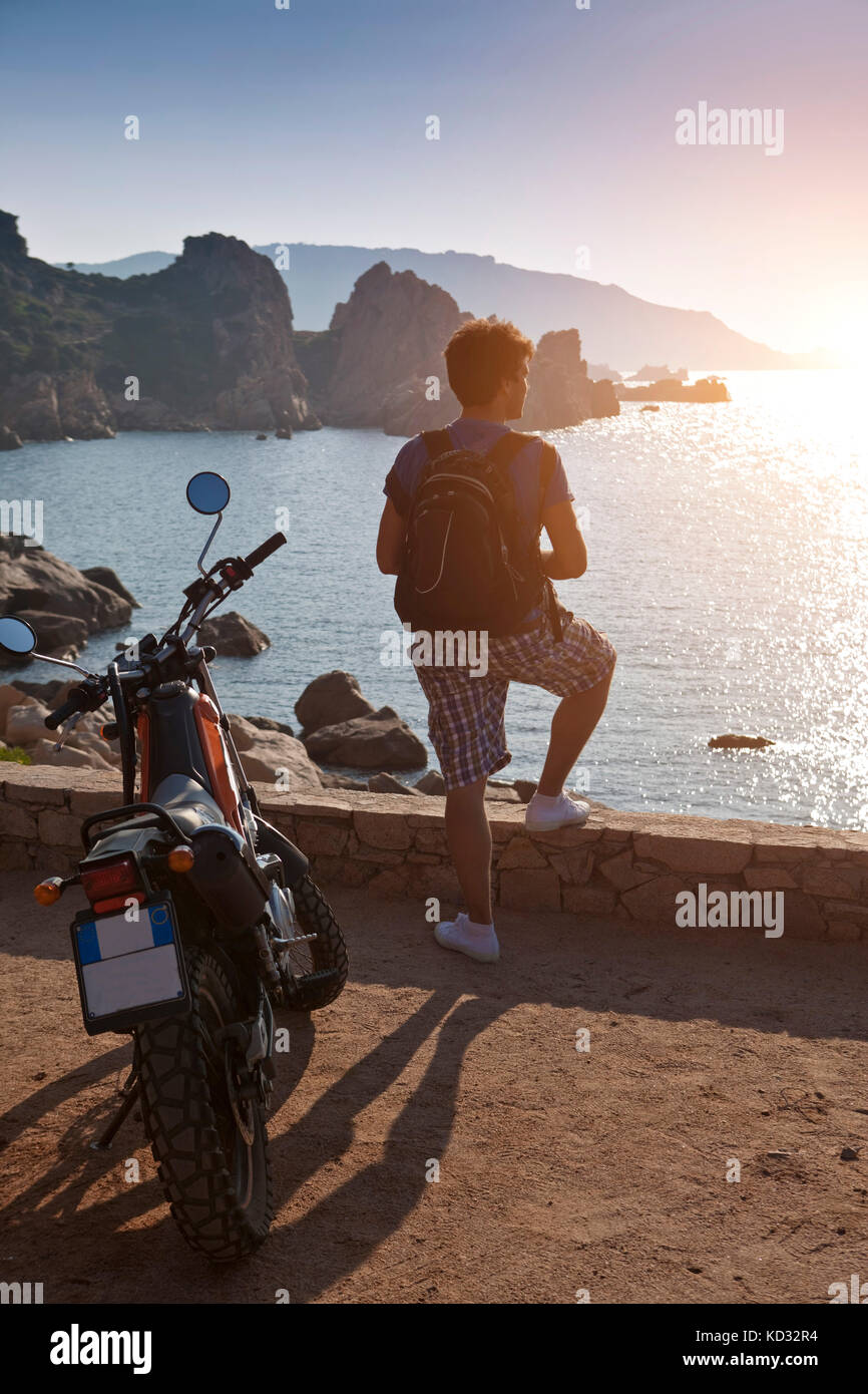 Uomo con la moto che guarda lontano in vista del tramonto sul mare, Olbia,  Sardegna, Italia Foto stock - Alamy