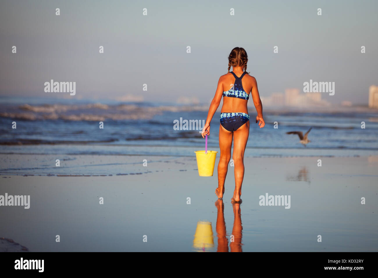 Vista posteriore di una ragazza sulla spiaggia tenendo la benna, North Myrtle Beach, Carolina del Sud, Stati Uniti, America del Nord Foto Stock