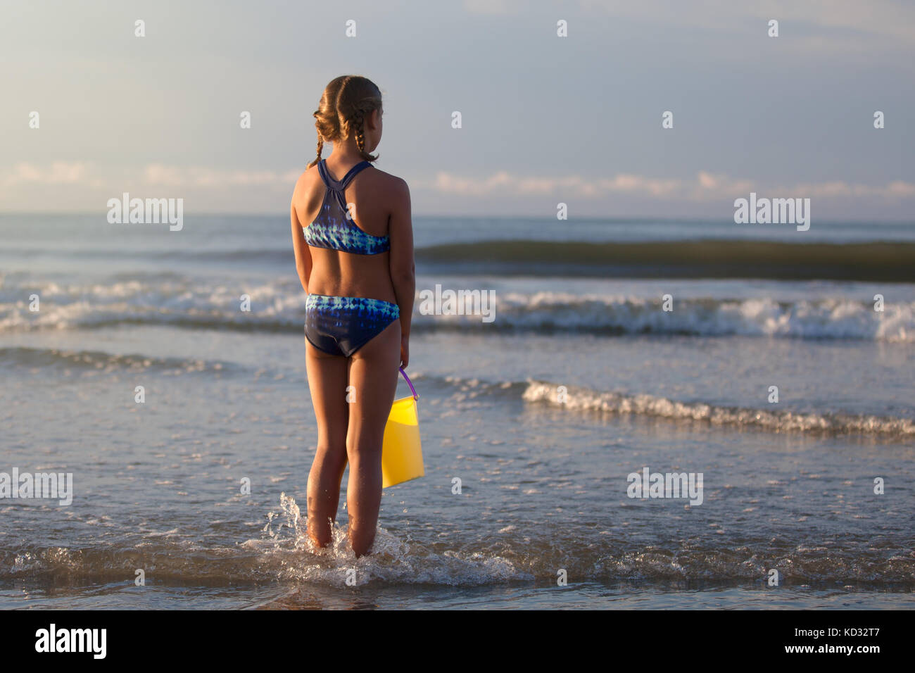 Vista posteriore di una ragazza sulla spiaggia tenendo la benna, North Myrtle Beach, Carolina del Sud, Stati Uniti, America del Nord Foto Stock