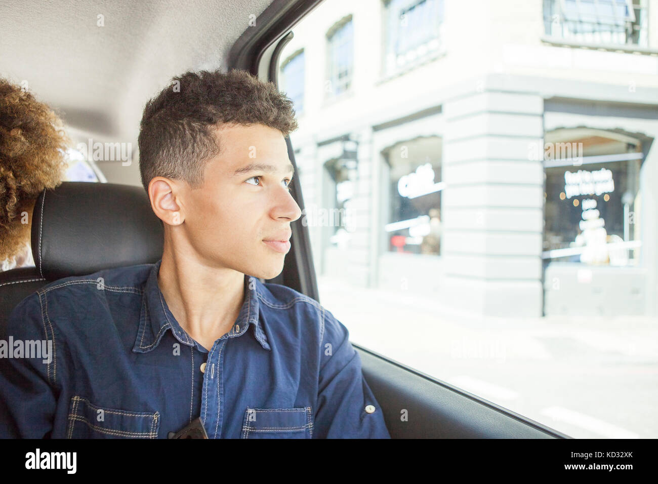 Giovane uomo nel sedile del passeggero di auto, guardando fuori della finestra Foto Stock
