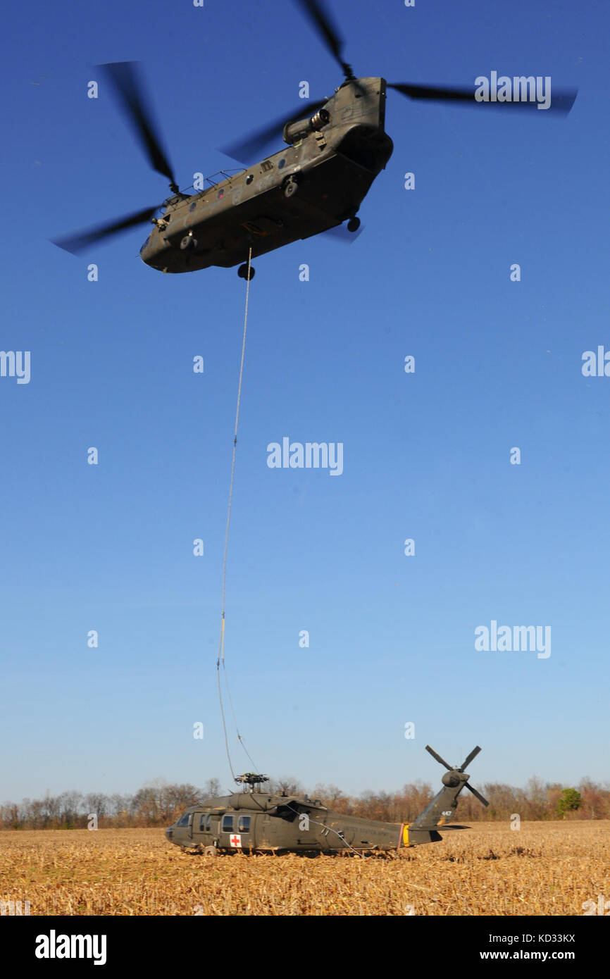 Stati Uniti I soldati della S.C. Esercito la Guardia Nazionale a lavorare per preparare un UH-60 Black Hawk dal distacco 2, società F, 1-171st supporto generale del battaglione di aviazione, S.C. Esercito Nazionale Guardia, per imbracare-movimento di carico a McEntire comune di Guardia Nazionale Base, Eastover, S.C. 7 dicembre, 2014. Il Falco nero ha fatto un atterraggio di emergenza in un campo aperto nel Dicembre 3, 2014 a causa di un rotore principale blade guasto in Columbia, S.C. Il Falco nero è stato rilasciato dall'incidente Review Board di recupero ed è stato trasportato via sling-carico sotto un S.C. Esercito nazionale Guard CH-47 elicottero Chinook dal distacco 1, B-società, Foto Stock