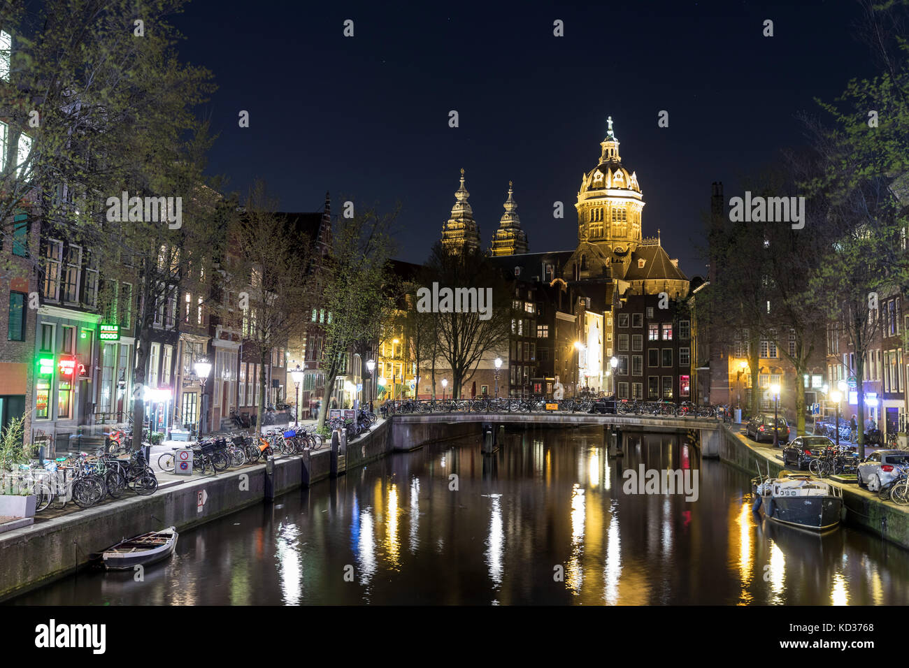 Amsterdam di notte, con St Nicholas Chiesa vista in distanza lungo la Voorburgwal Foto Stock