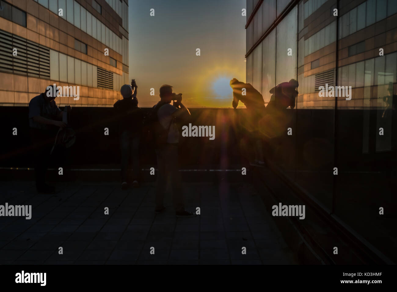 Fotografi sul tetto sparare il tramonto in una città moderna. retroilluminazione Foto Stock