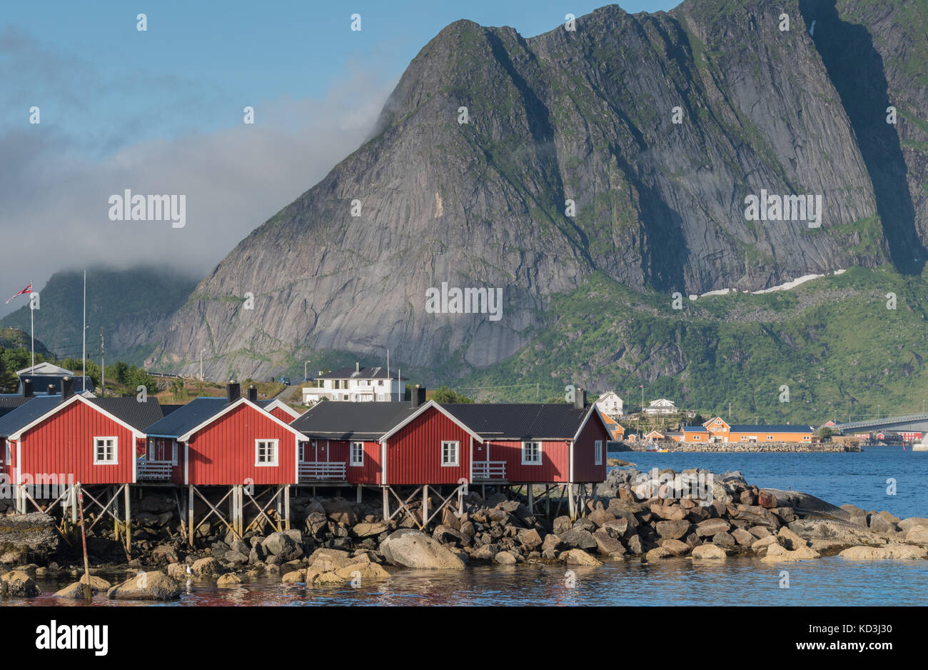 Pescatore tradizionale rorbu, cottage, capanne in isole Lofoten. maestose montagne e nuvole in background Foto Stock