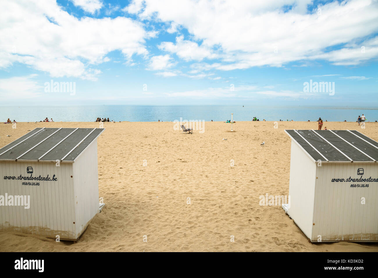 Ampia foto della spiaggia con persone, spiaggia di capanne, gabbiani in una giornata di sole con nuvole. oostende, Belgio. Foto Stock