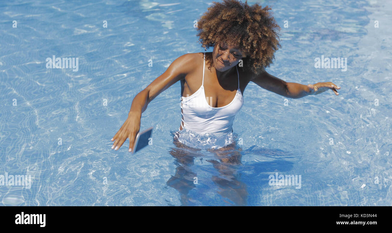 Donna far cadere il telefono in piscina Foto Stock