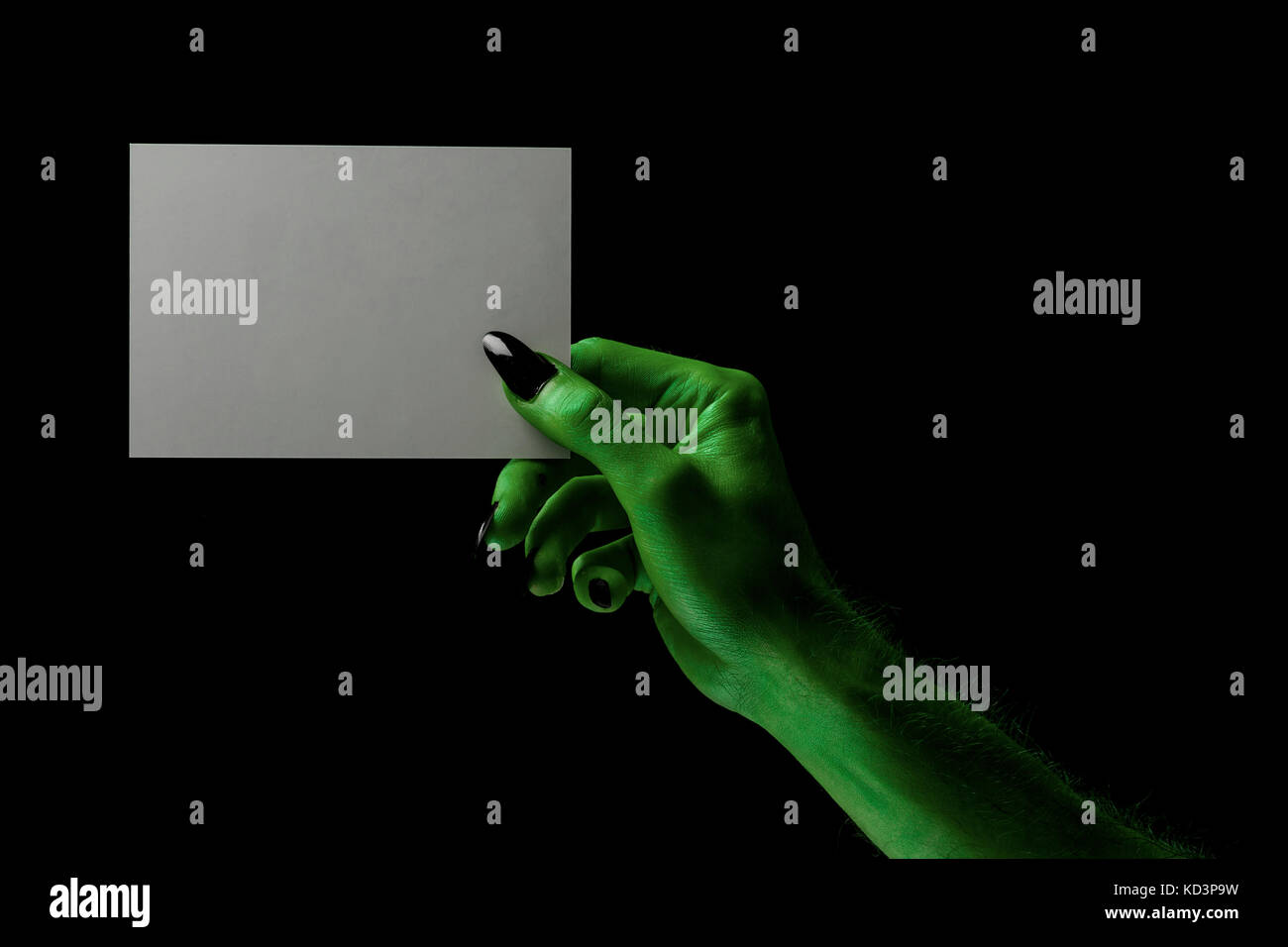 Halloween streghe verdi o zombie monster mano che tiene un cartello bianco Foto Stock