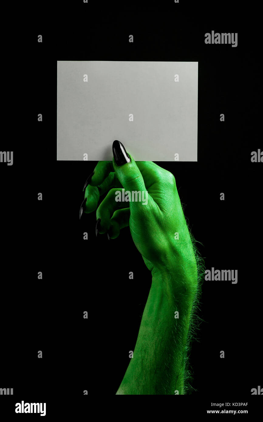 Halloween streghe verdi o zombie monster mano che tiene un cartello bianco Foto Stock