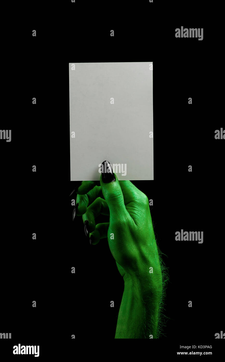Halloween streghe verdi o zombie monster mano che tiene un cartello bianco Foto Stock