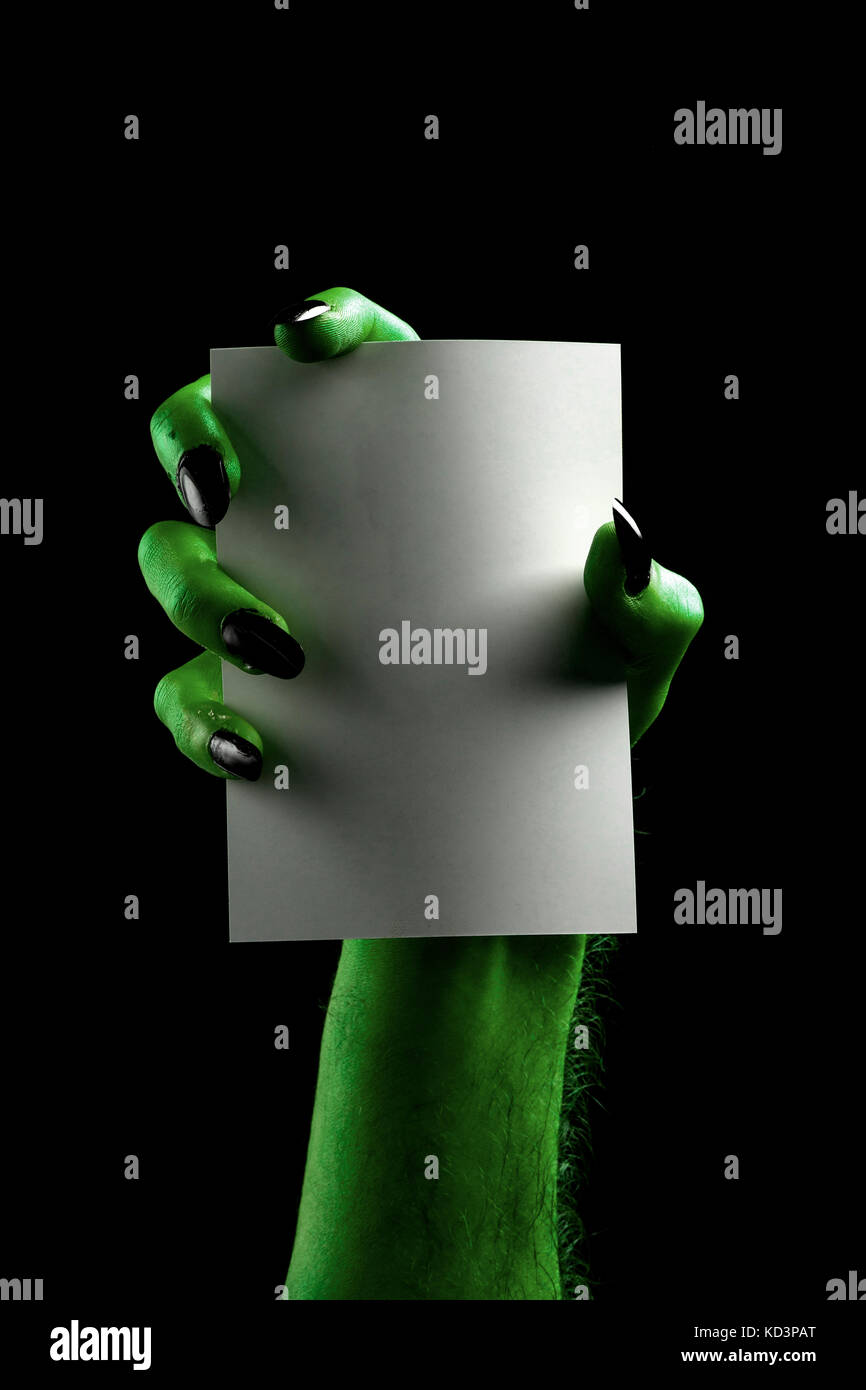 Halloween streghe verdi o zombie monster mano che tiene un cartello bianco Foto Stock