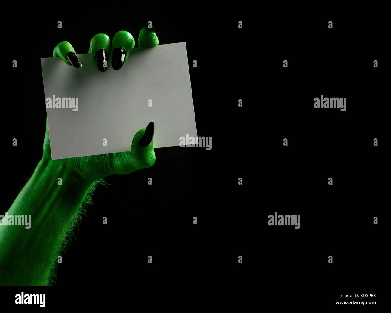 Halloween streghe verdi o zombie monster mano che tiene un cartello bianco Foto Stock