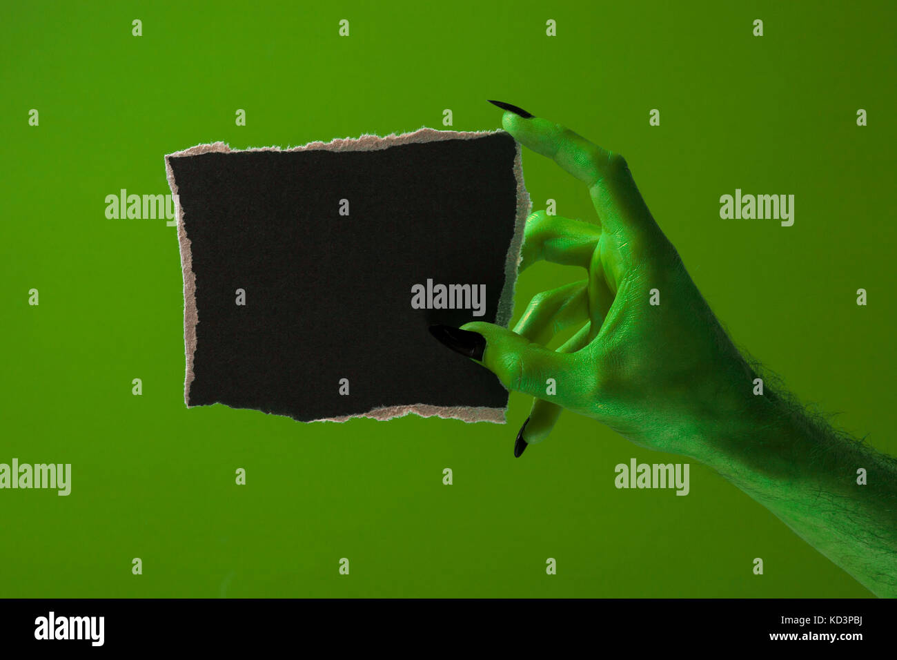 Halloween streghe verdi o zombie monster mano che tiene un cartello bianco Foto Stock