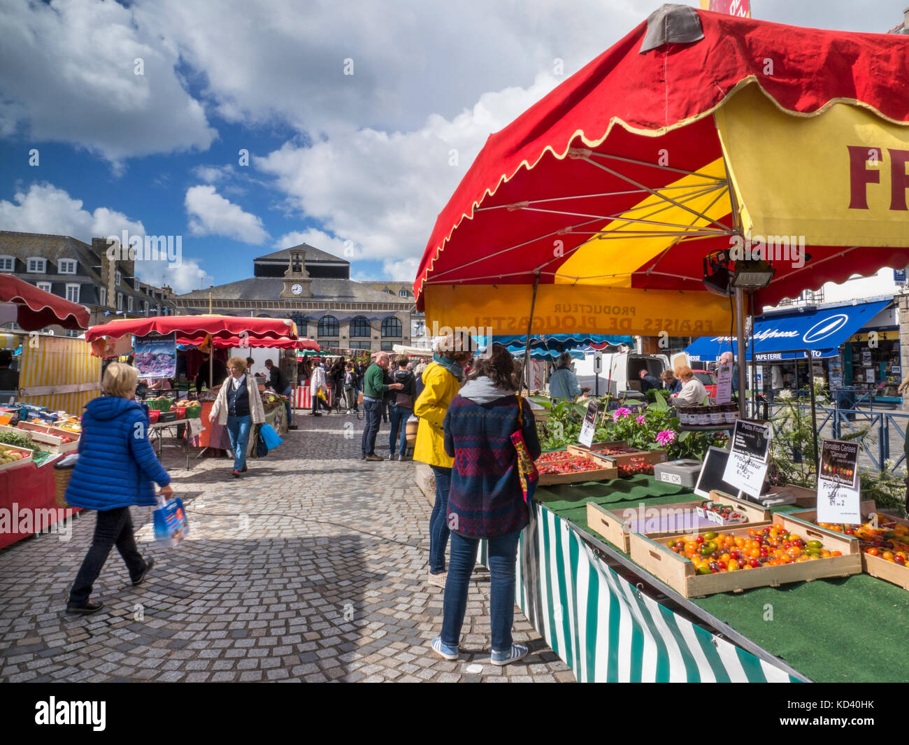 CONCARNEAU MERCATO ALL'APERTO Francese fresco produrre in vendita al giorno di mercato in piazza con mercato coperto in background Concarneau Bretagna Francia Foto Stock