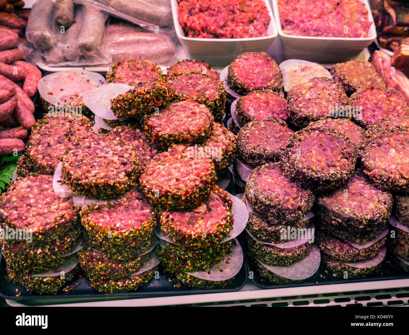 CONCETTO DI SALUTE DEL CONSUMO DI CARNE hamburger di manzo crudo, macine e salsicce in esposizione per la vendita nei macellai refrigerati armadietto Quimper Brittany Francia Foto Stock