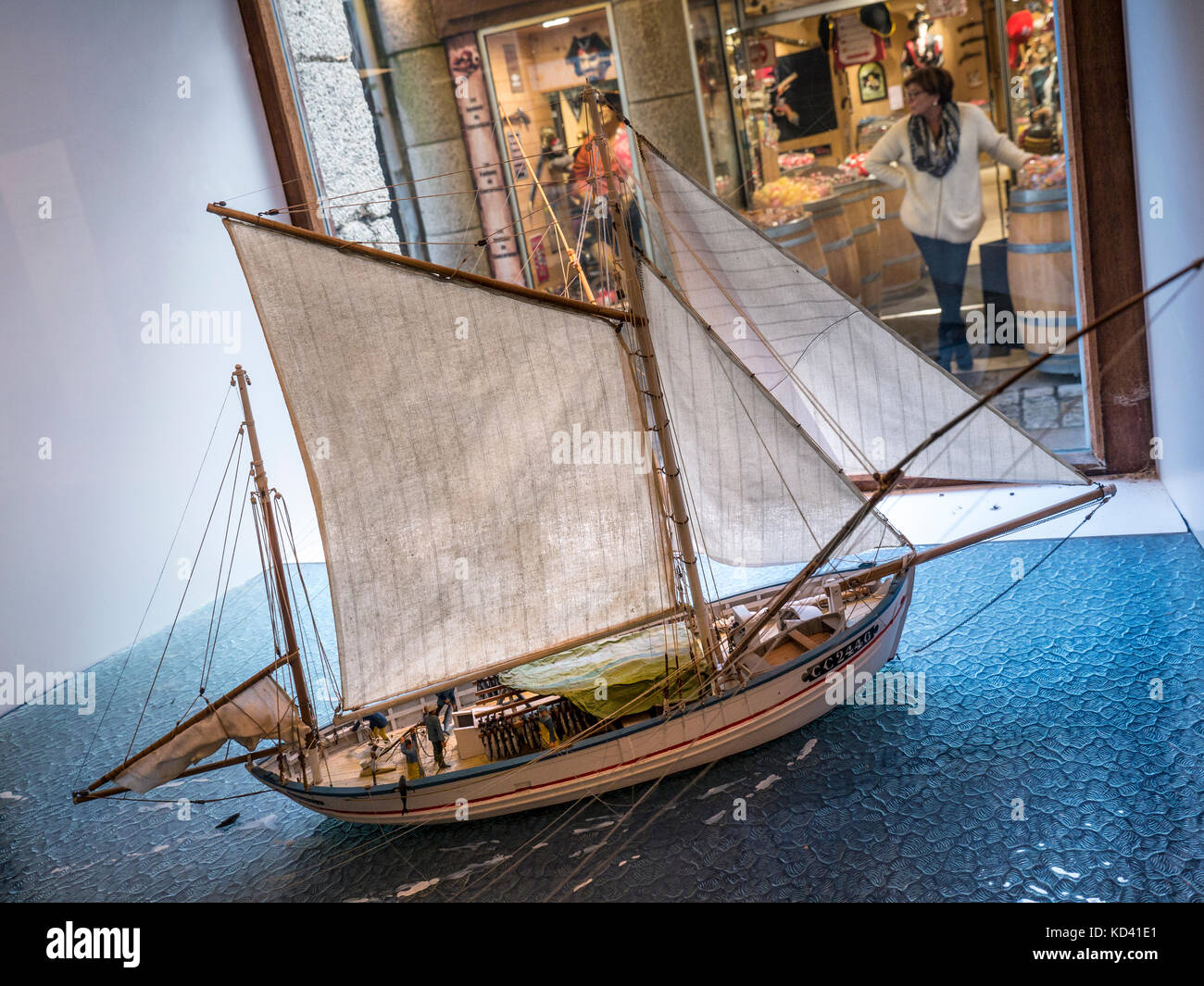 1900 Concarneau francese pesca barca modello in scala in vetro con shopping arcade in background Concarneau Bretagna Francia Foto Stock