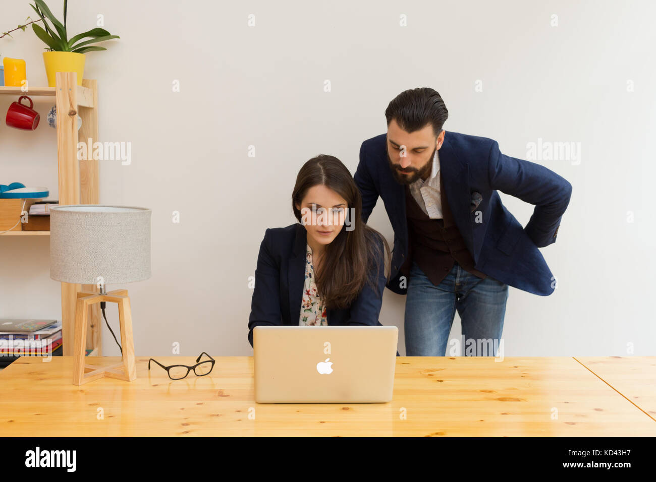 I colleghi in ufficio a lavorare insieme su laptop Foto Stock