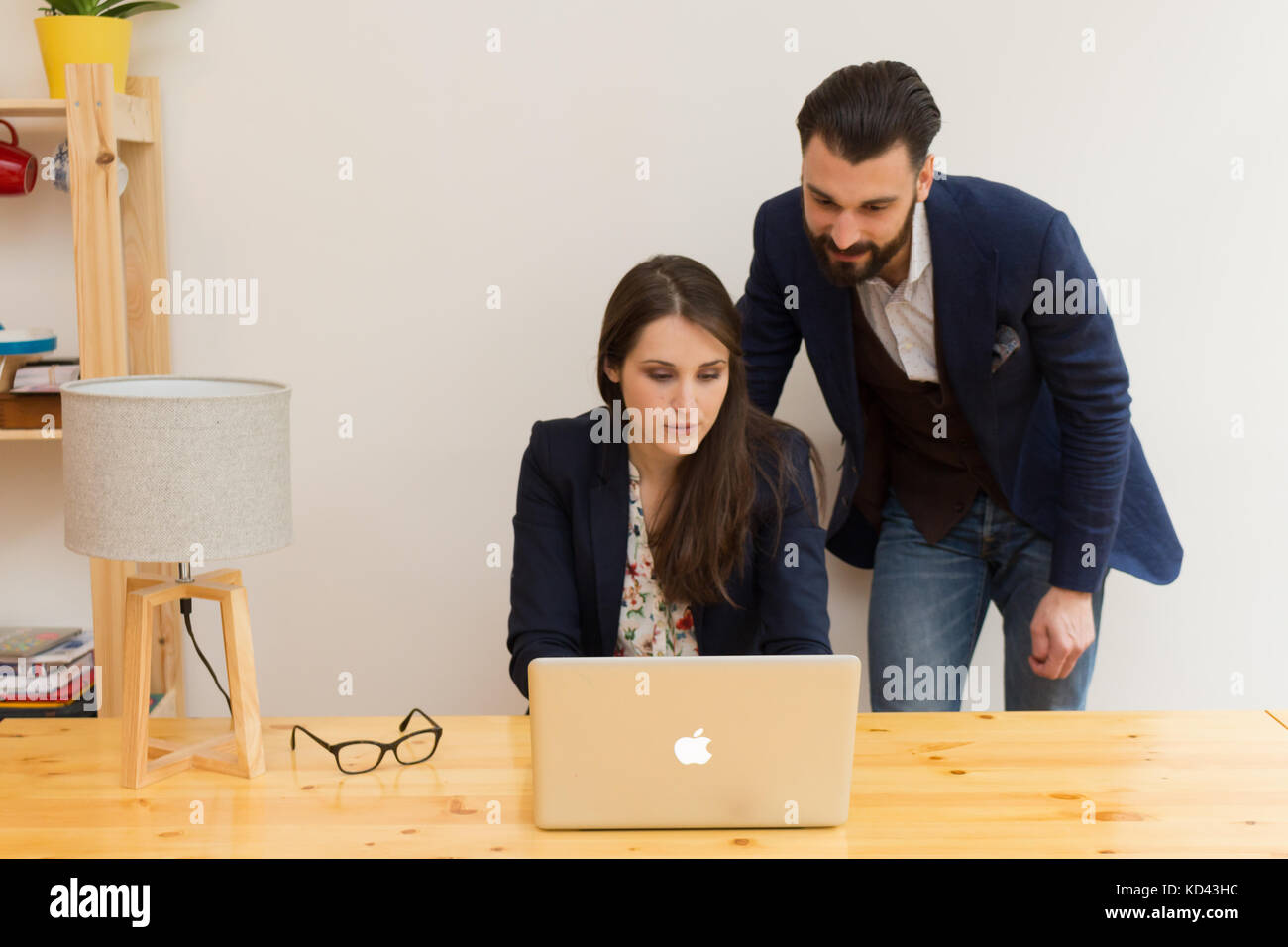 I colleghi in ufficio a lavorare insieme su laptop Foto Stock