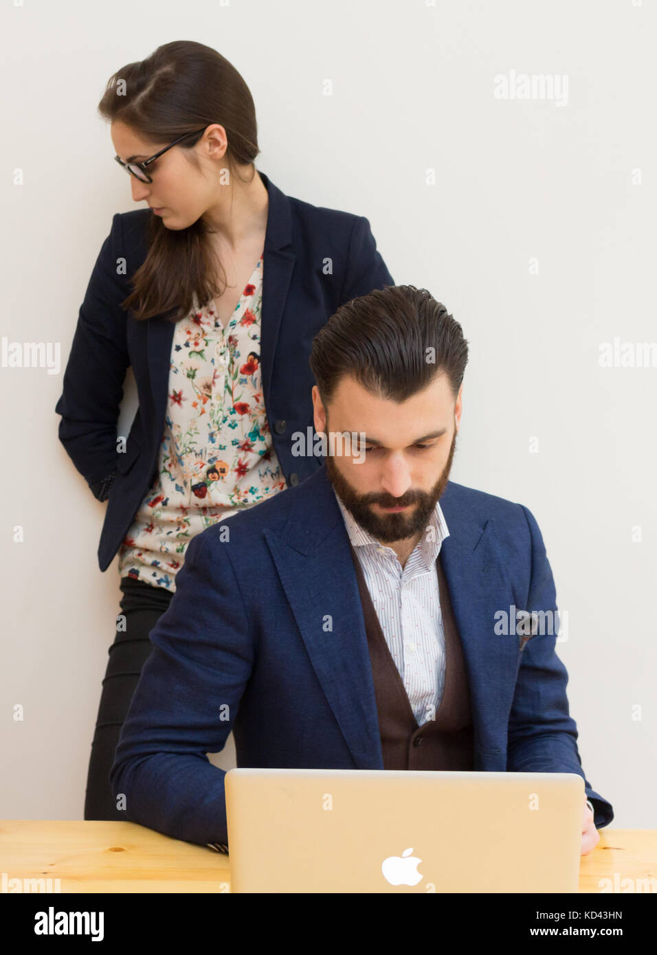I colleghi in ufficio a lavorare insieme su laptop Foto Stock