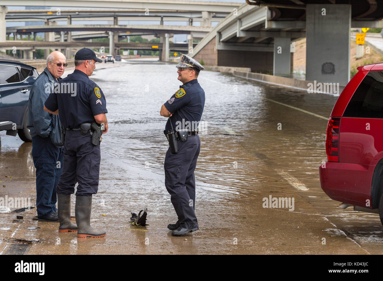La polizia e i funzionari della città a guardia della chiusa in autostrada in Houston Texas a seguito di devastanti inondazioni in città Foto Stock