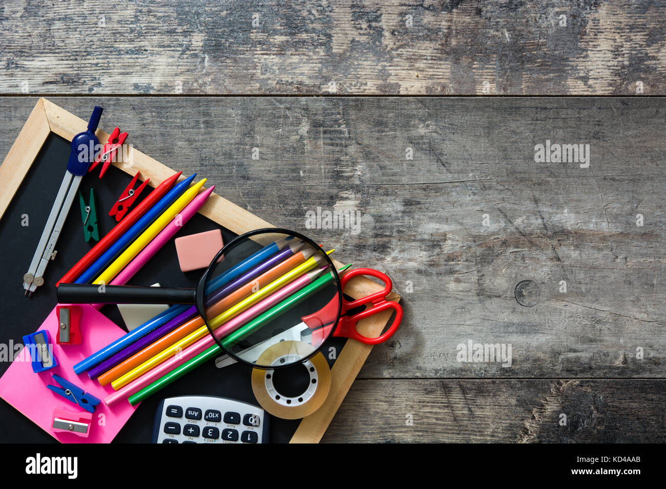Forniture scolastiche su sfondo di legno. Si torna a scuola concetto. Copyspace. Foto Stock