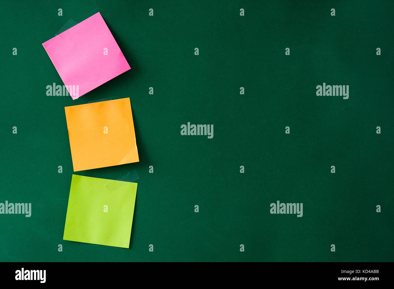 Stick colorati note su sfondo verde. Copyspace. Foto Stock