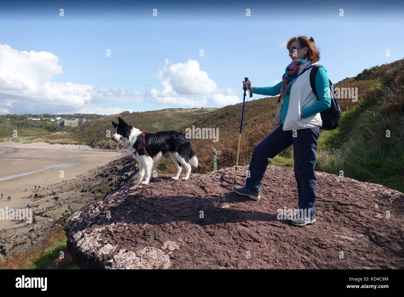 La donna e il cane a camminare Pembrokeshire Coast Path a Manorbier Beach in Pembrokeshire Foto Stock