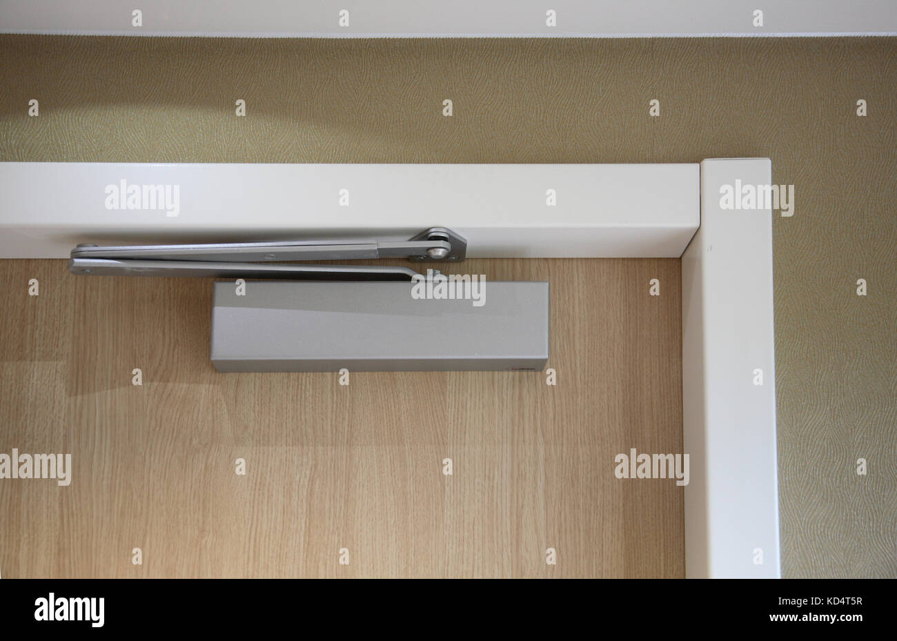 Primo piano di una moderna porta della camera d'hotel che mostra il chiudiporta e altri accessori per soddisfare le più recenti normative antincendio Foto Stock