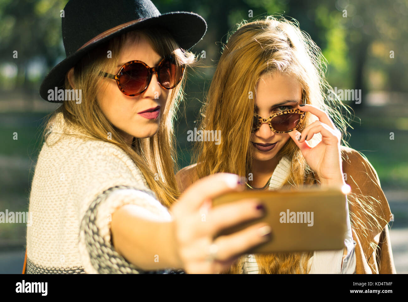 Due amiche tenendo selfie nel parco Foto Stock