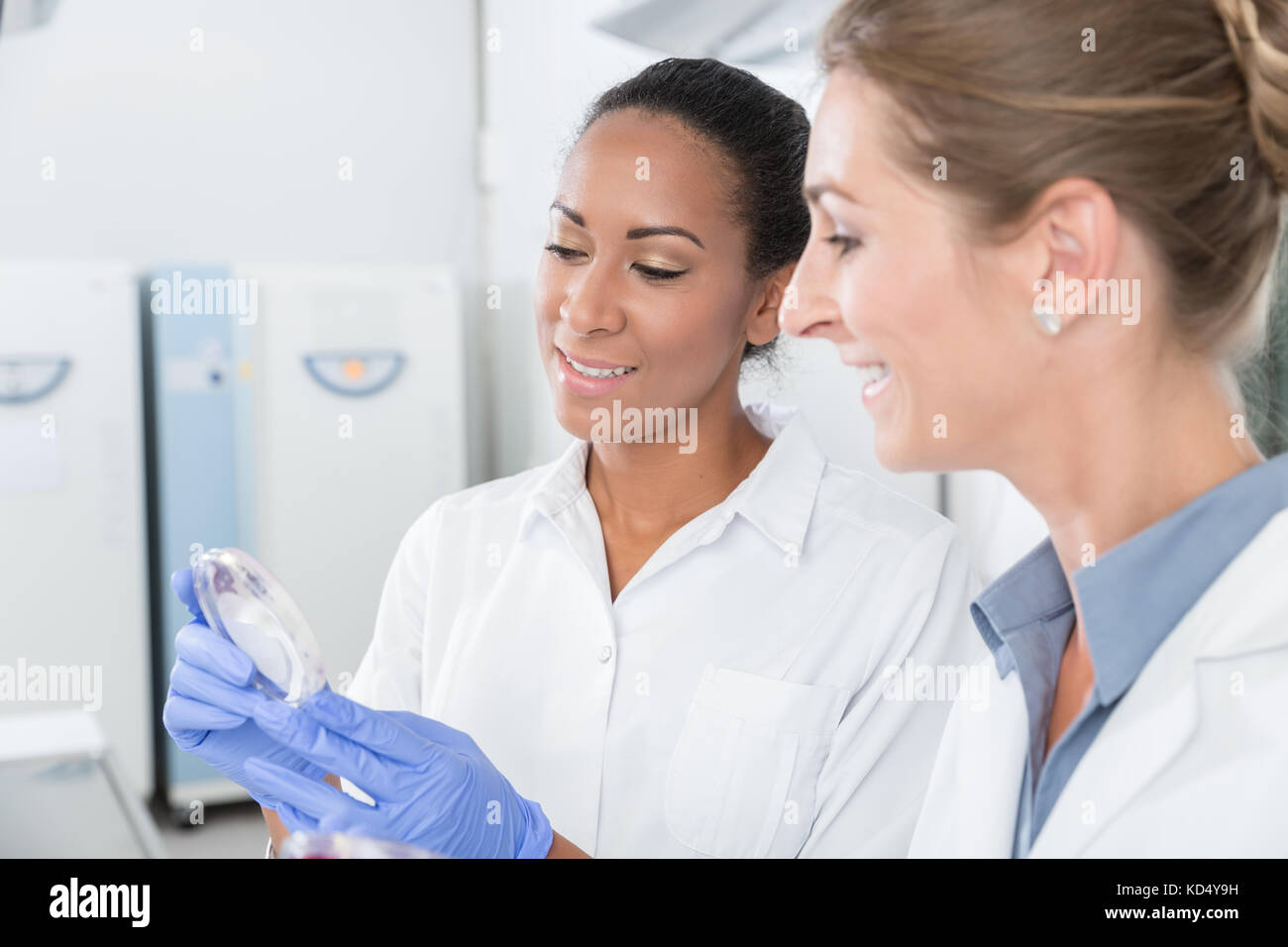 Gli scienziati in laboratorio di ricerca con strumento di analisi parlando di abo Foto Stock