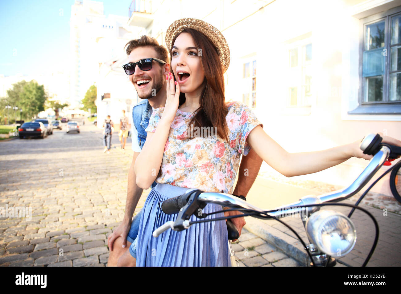 Felice coppia giovane di andare per un giro in bici su un giorno di estate in città.si stanno divertendo insieme. Foto Stock