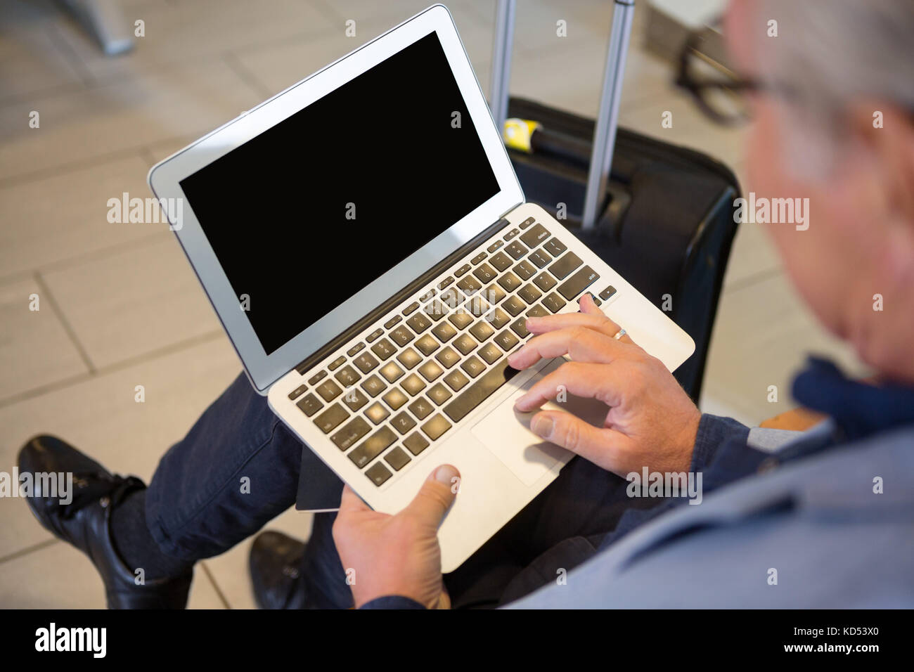 Closeup dell uomo d affari con computer portatile mentre si è in attesa per il volo nella lobby Foto Stock