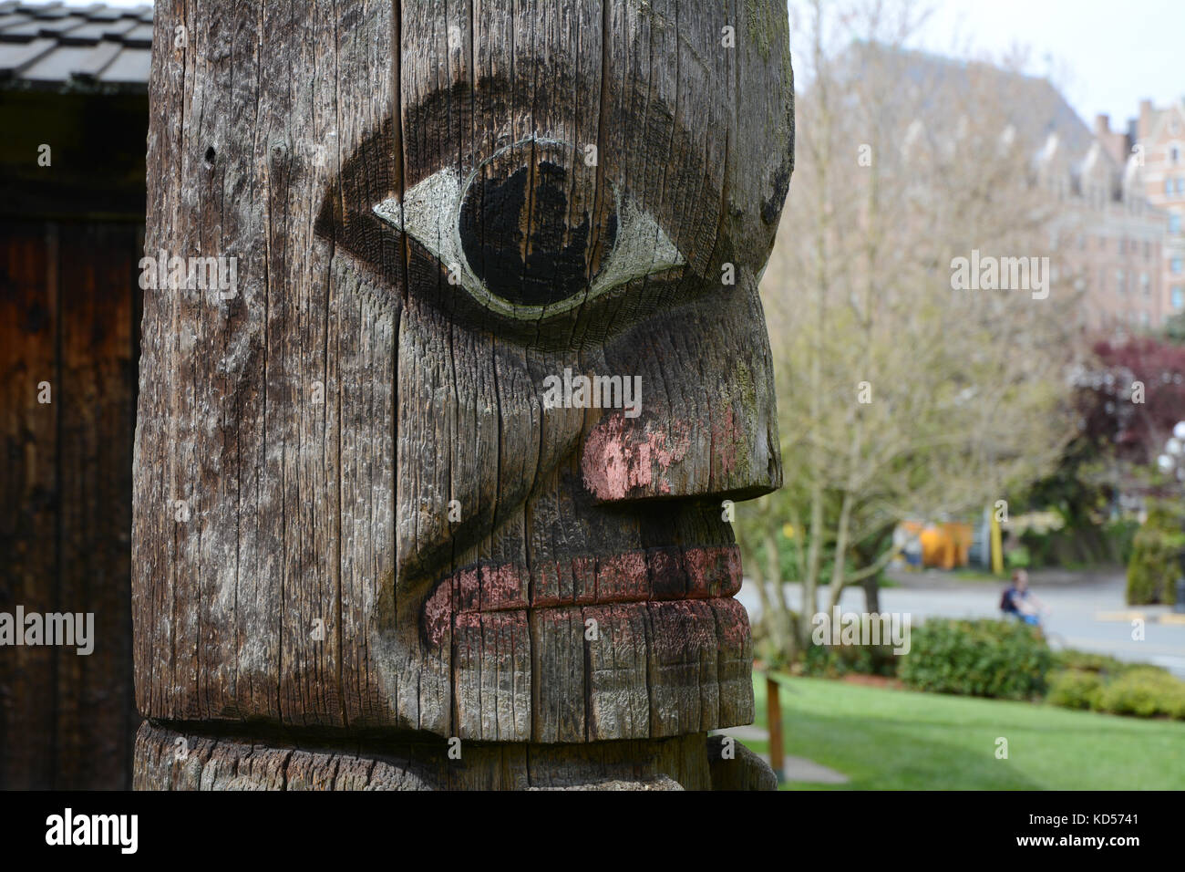 Una rappresentazione di un volto umano su un vecchio della Costa Northwest Totem indigeni pole, in Victoria, British Columbia, Canada. Foto Stock
