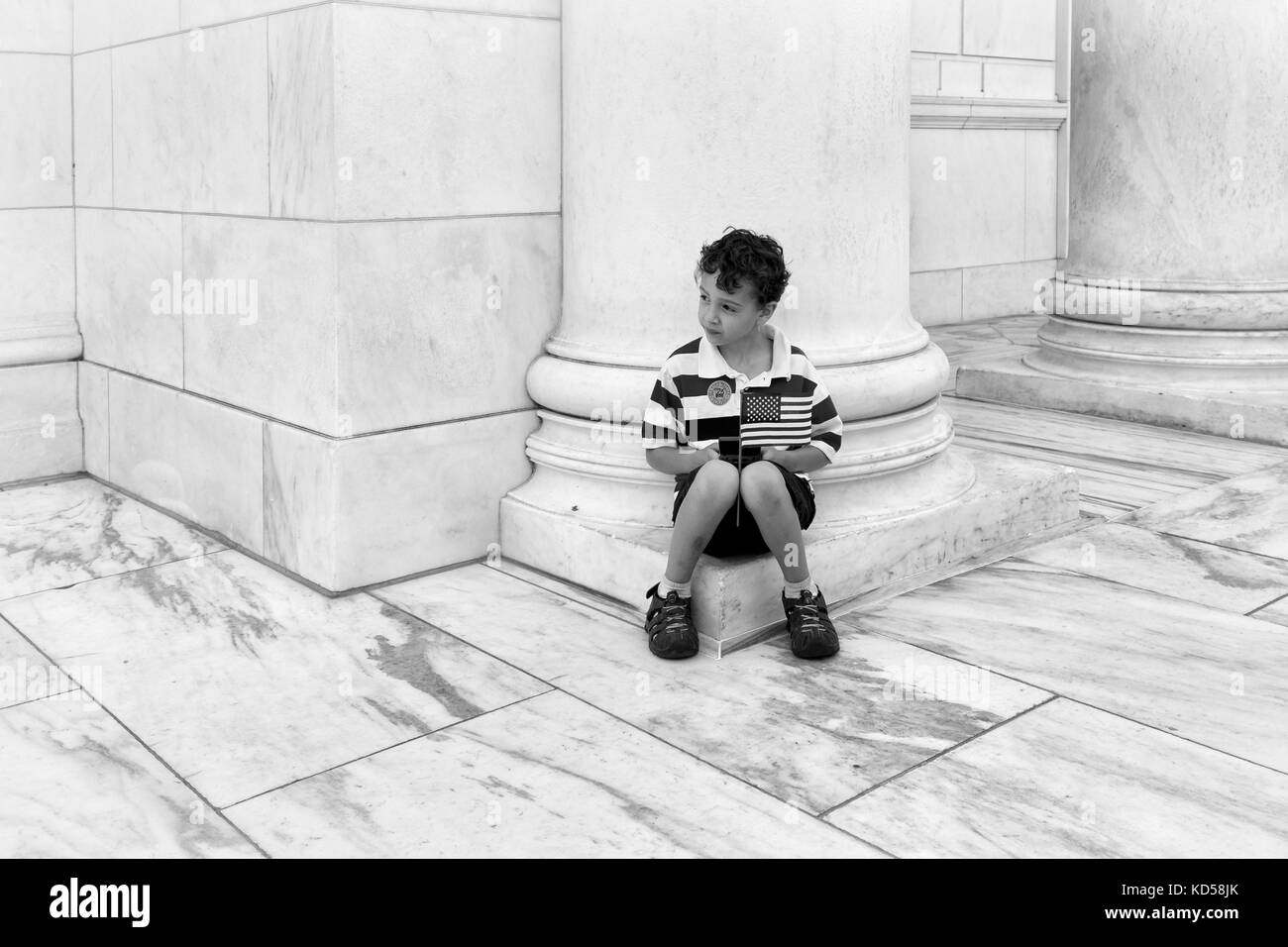 Washington dc-maggio 25, 2015: unidentified bambino tiene una bandiera americana del memorial day al marmo bianco memorial anfiteatro presso il Cimitero di Arlington Foto Stock