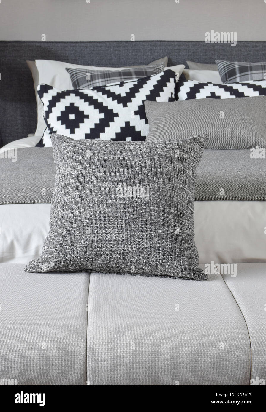 Cuscino grigio sul banco di lavoro con biancheria da letto monotono Foto Stock