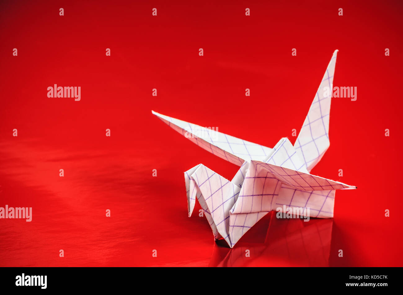 Origami gru su sfondo rosso Foto Stock