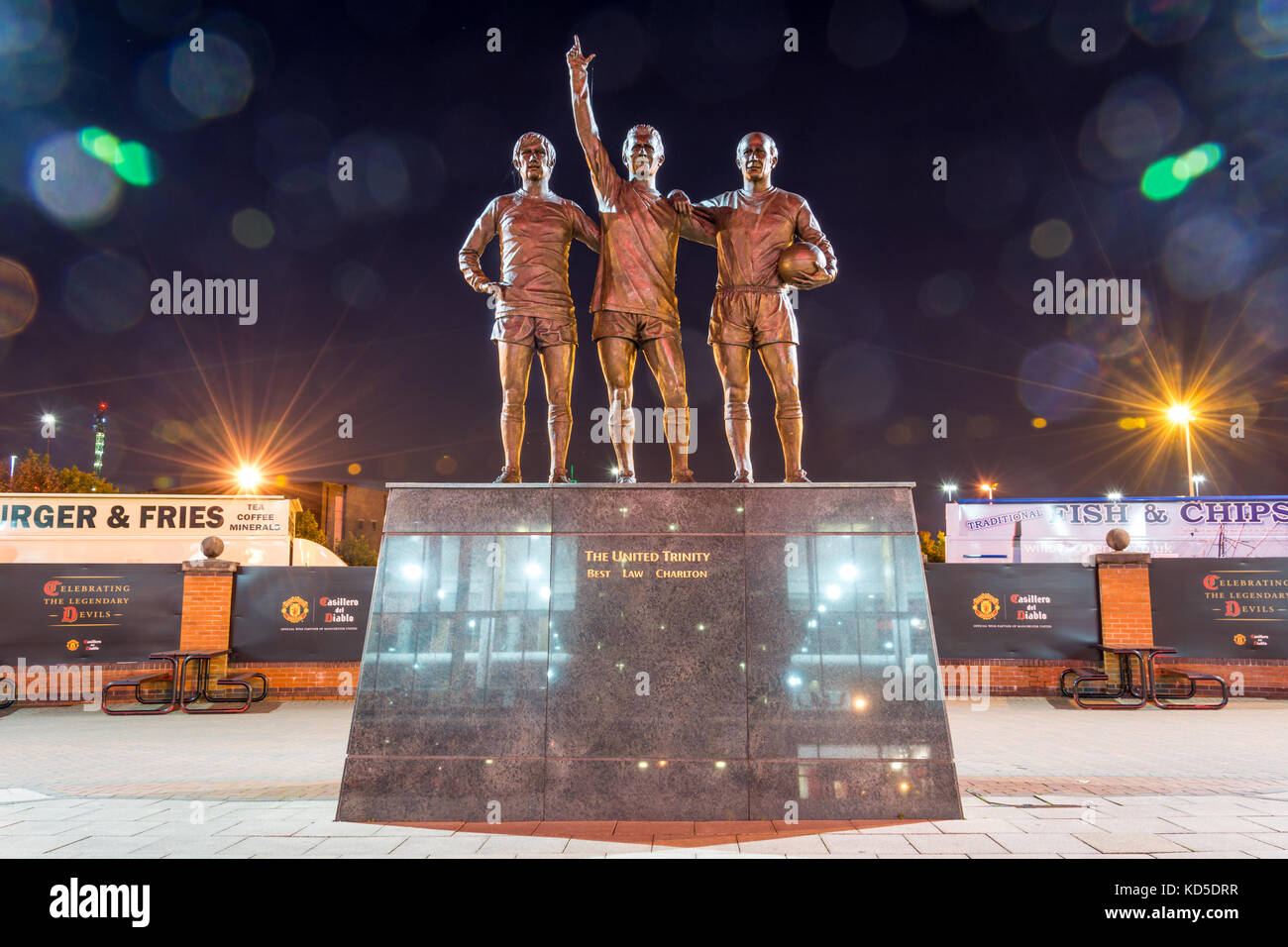 Manchester, Inghilterra - Settembre 29, 2017: lo stadio Old Trafford e la statua del " regno trinità' nella notte in Manchester Foto Stock