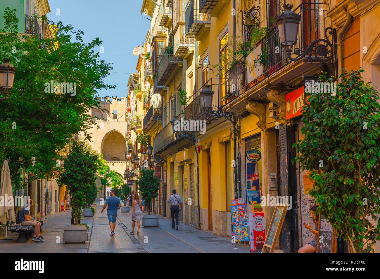 Città di Valencia, vista posteriore di una coppia a piedi verso la porta della città di Torres Serranos nel quartiere storico della città vecchia di Valencia, Spagna. Foto Stock