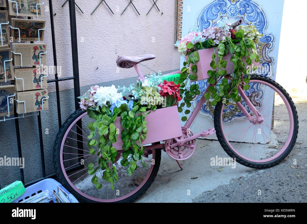 Bicicletta rosa coperta di fiori al di fuori di un negozio a Sintra Portogallo Foto Stock
