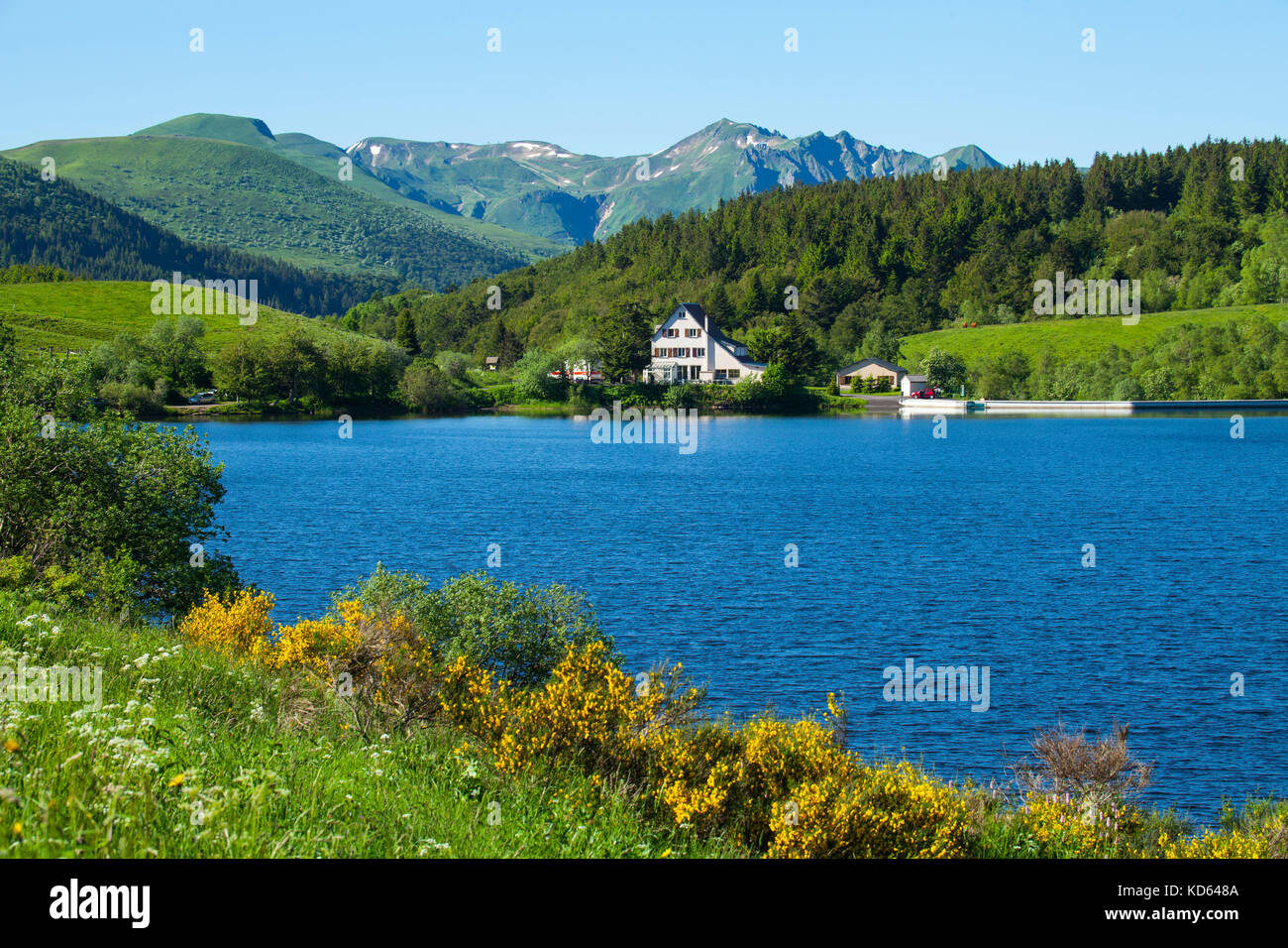 Massiccio Centrale monti: il lago Guery, inn e vista sul "Chaine des Puys' Mountain Range. (Non disponibile per la produzione di cartoline). Foto Stock