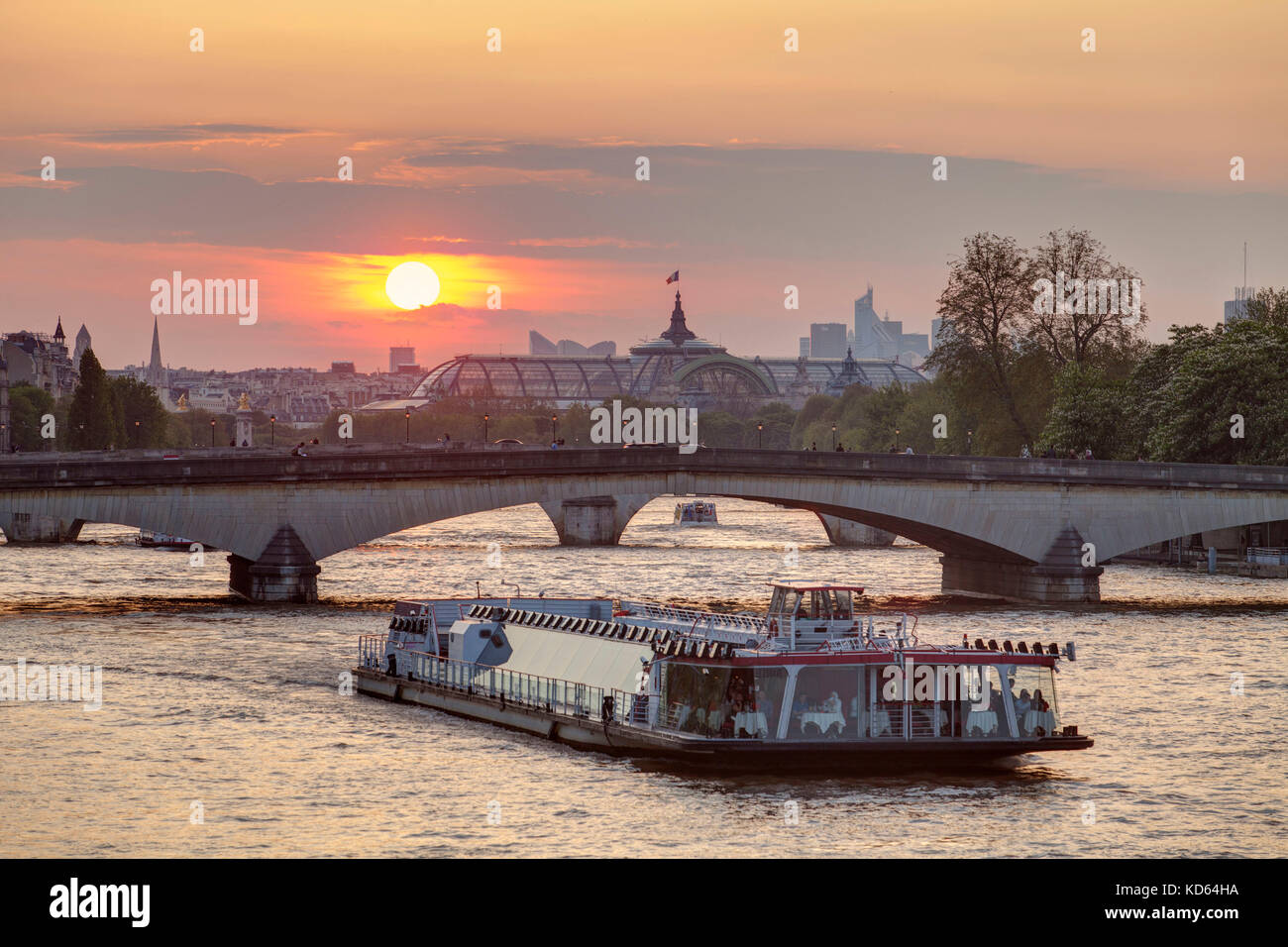 Parigi (Francia): tramonto sulla città capitale. Tourist barca fluviale sul fiume Senna e il tetto di vetro del Grand Palais di Parigi ottavo arrondissement / d Foto Stock