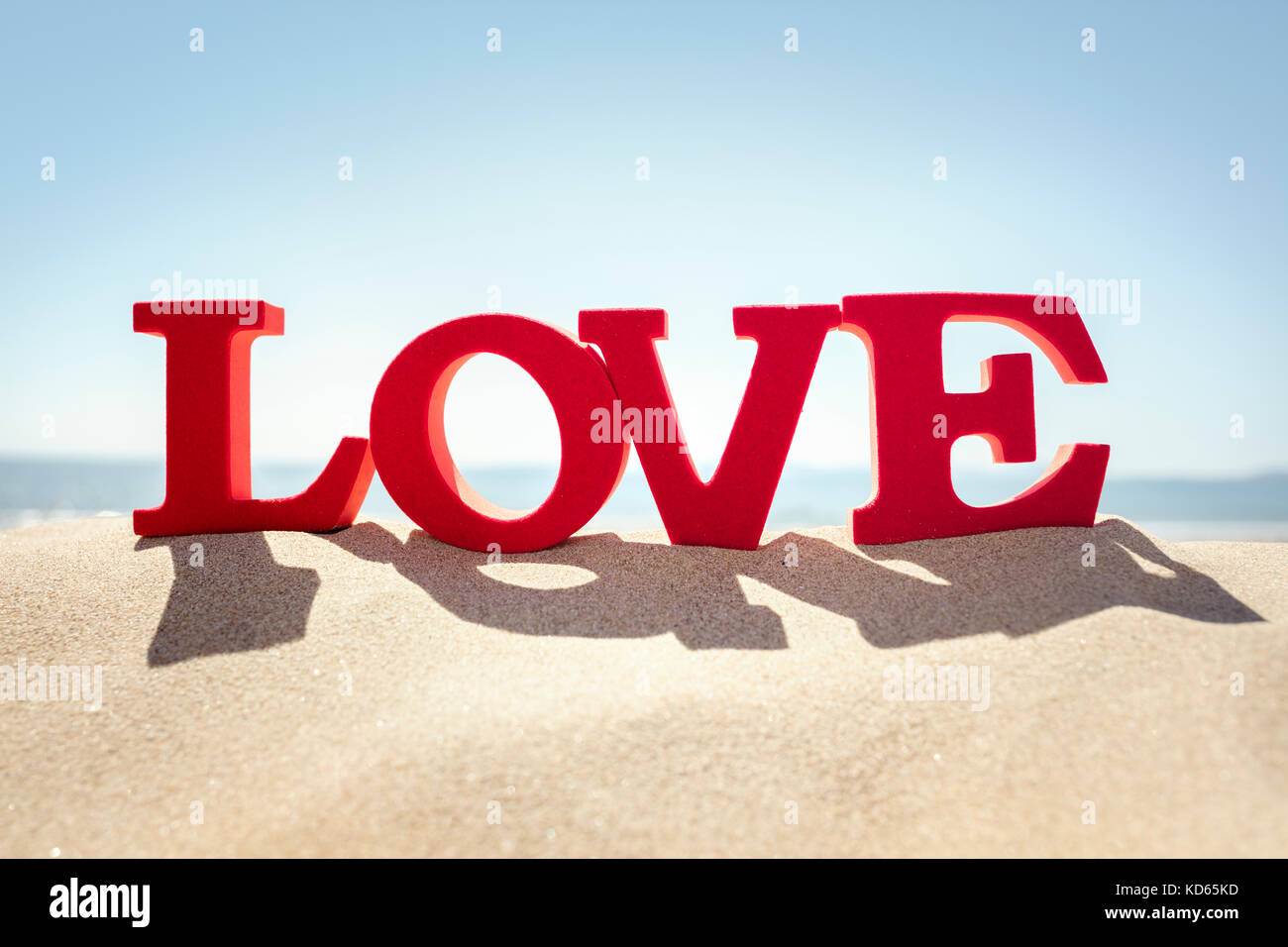 Amore parola su una spiaggia di sabbia di concetto per il romanticismo o vacanze romantiche e vacanze Foto Stock