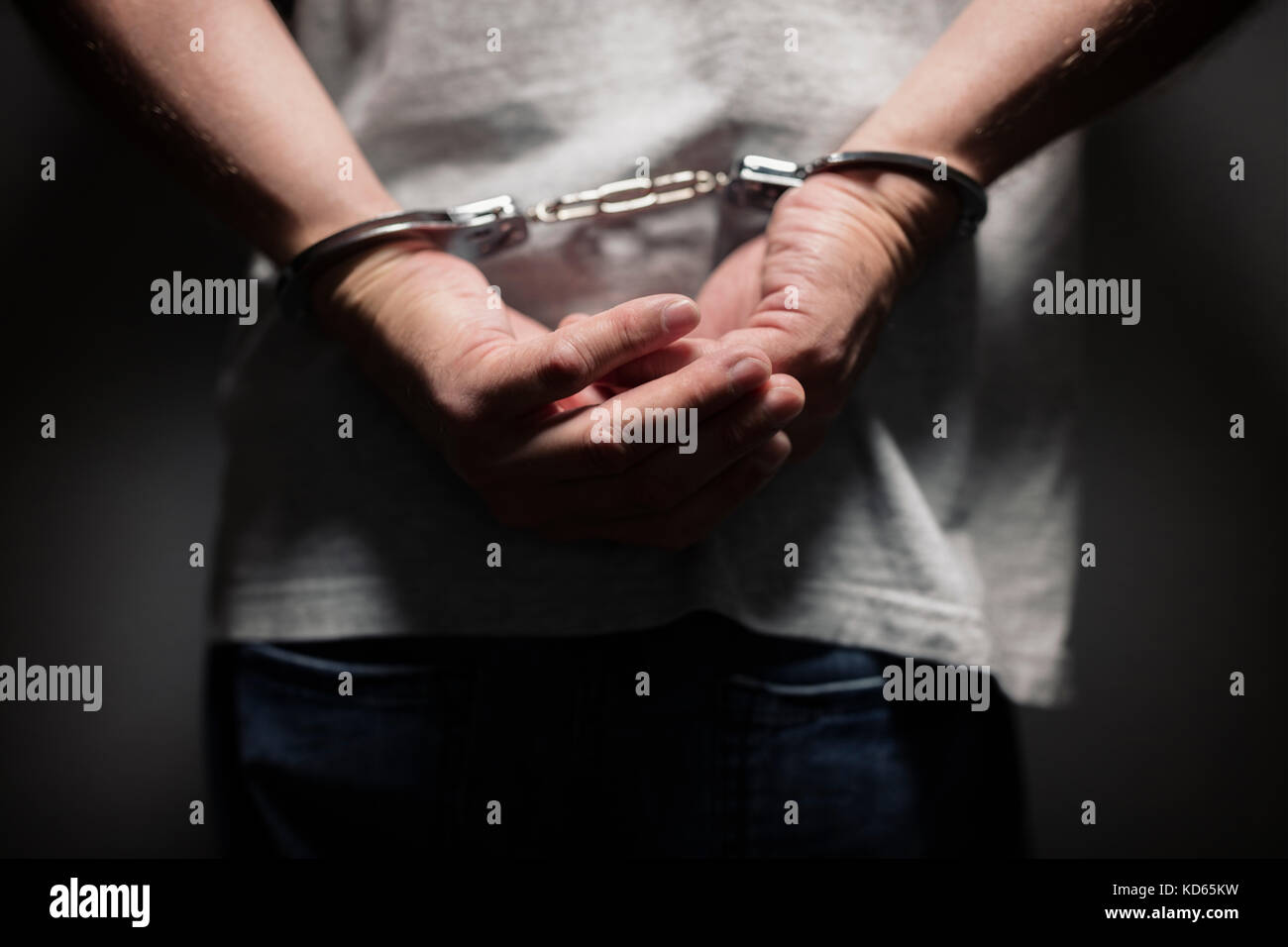 Arrestato uomo in manette ammanettato con le mani dietro la schiena Foto Stock