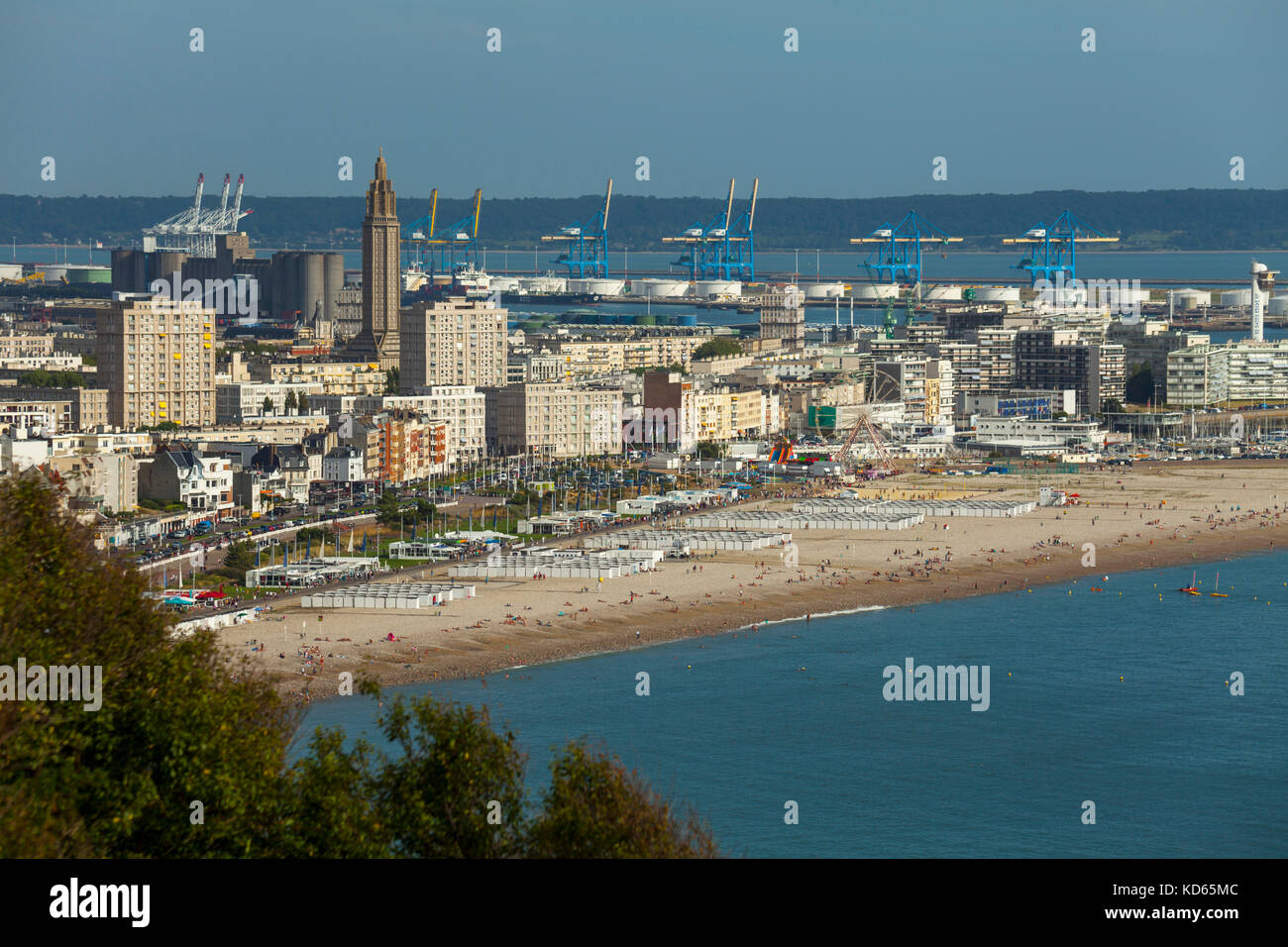 Le Havre (nord-ovest della Francia): il lungomare e la spiaggia, gli edifici e la chiesa di Saint-Joseph con il porto commerciale in background. Le Ha Foto Stock